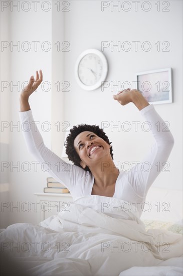 Happy Black woman awaking in bed