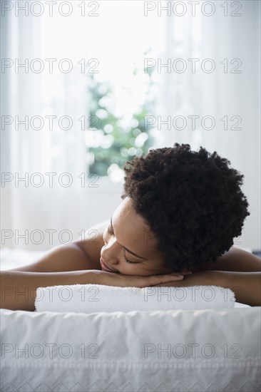 Serene Black woman laying on massage table