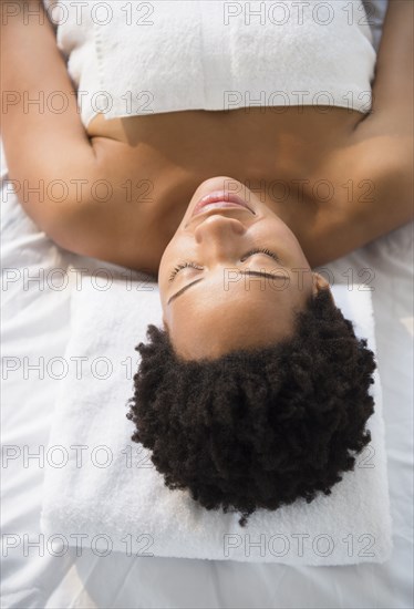 Serene Black woman laying on massage table