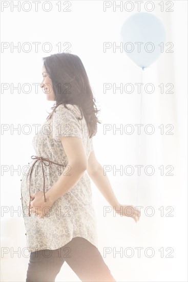 Pregnant Hispanic woman walking