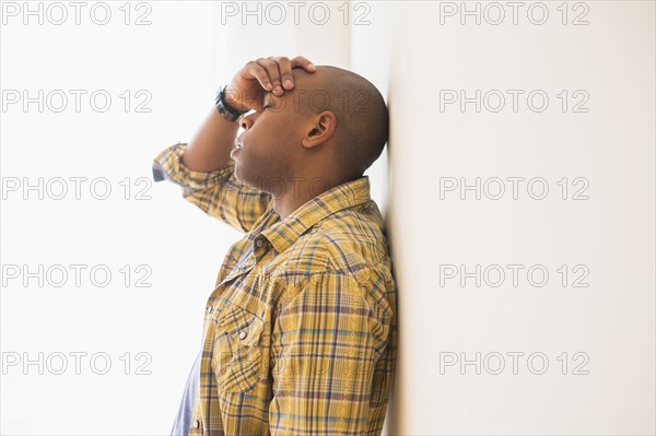 Black man rubbing his forehead