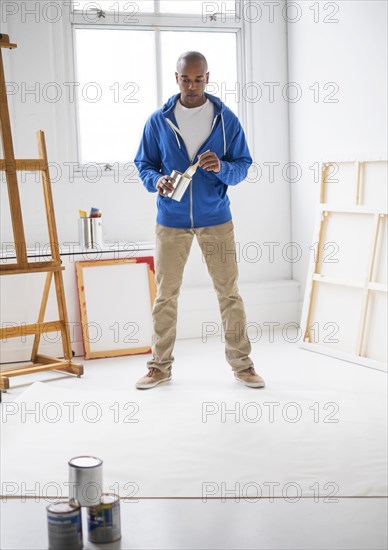 Black artist painting in studio