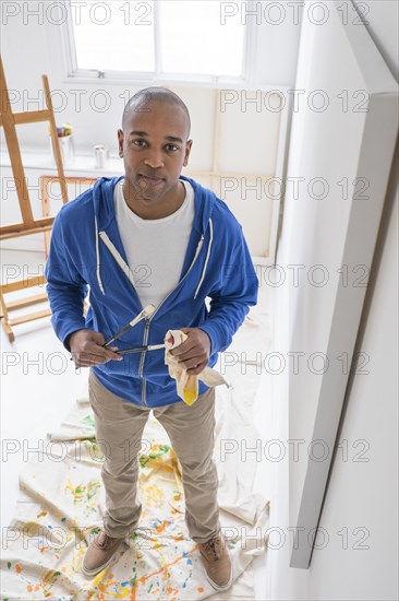 Black artist painting in studio