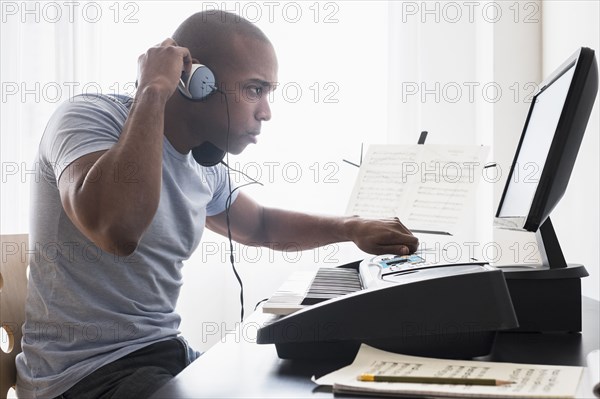 Black musician writing music with computer