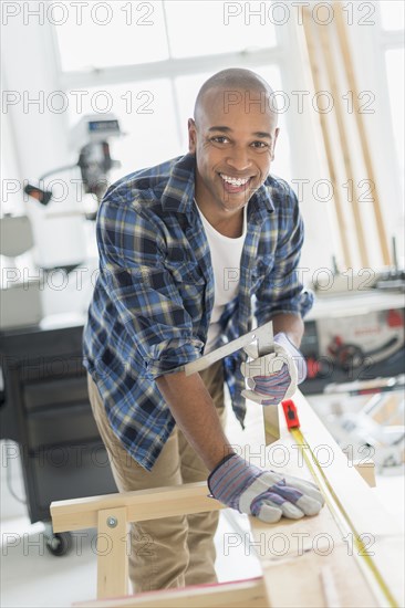 Black carpenter working in shop