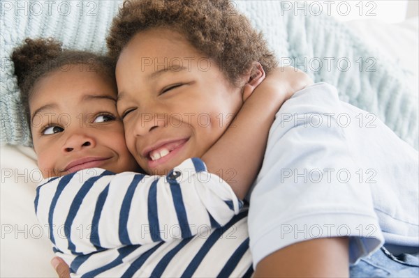Black children hugging on sofa