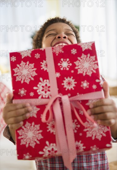 Black boy holding Christmas present