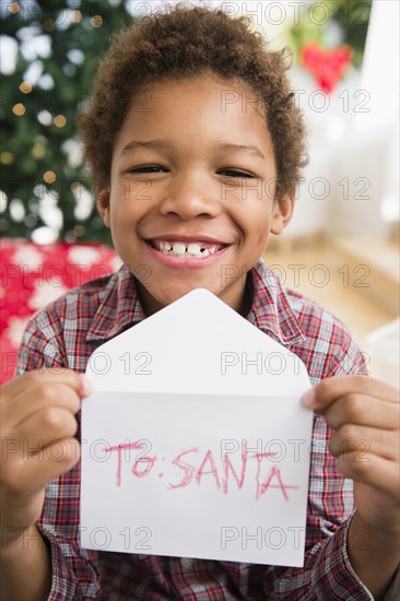 Black boy holding letter to Santa Claus