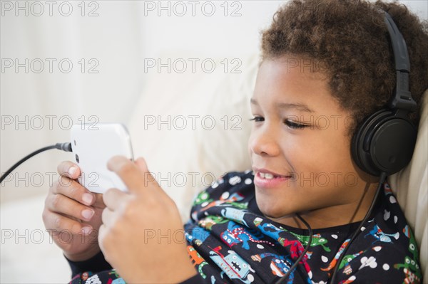 Black boy listening to headphones on sofa