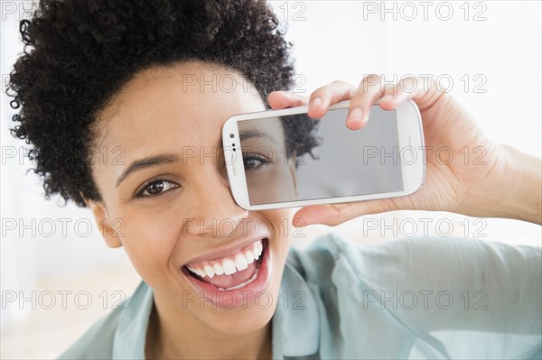 Black woman holding photo of her eye over her face