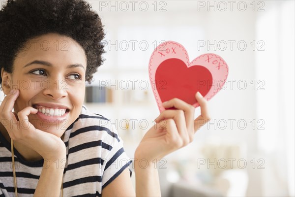 Black woman holding heart-shape Valentine