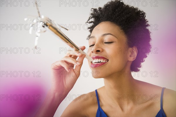 Black woman blowing noisemaker at party