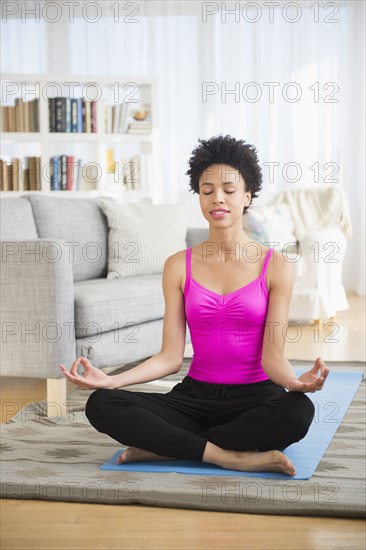 Black woman meditating on yoga mat