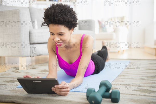 Black woman using digital tablet to work out