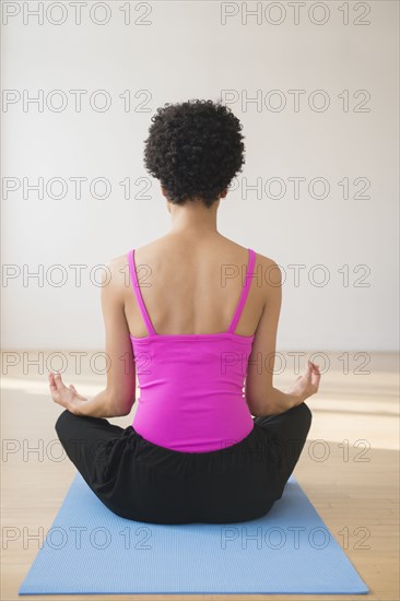 Black woman meditating on yoga mat