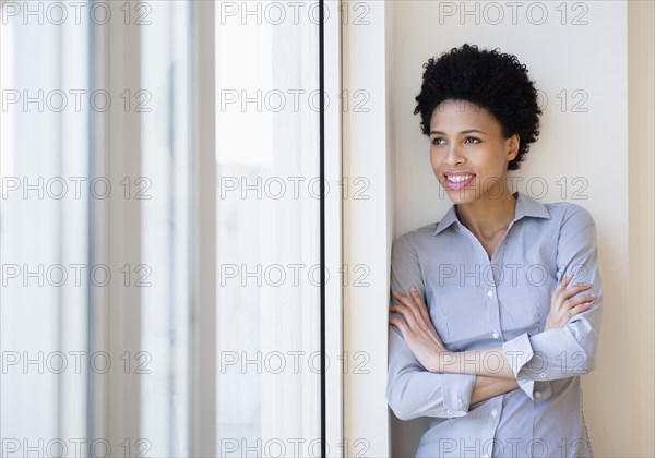 Black businesswoman smiling by window