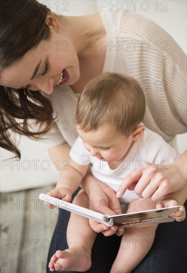 Mother and baby reading in living room