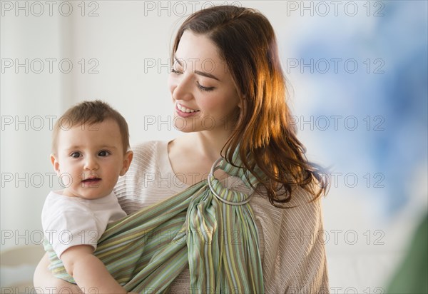 Mother carrying baby in sling