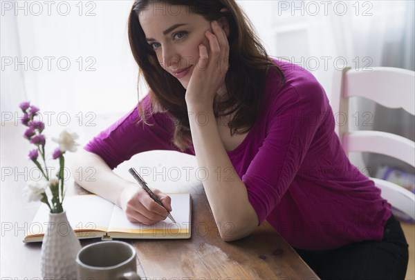 Woman writing in journal at desk