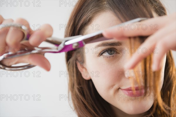 Woman trimming her bangs