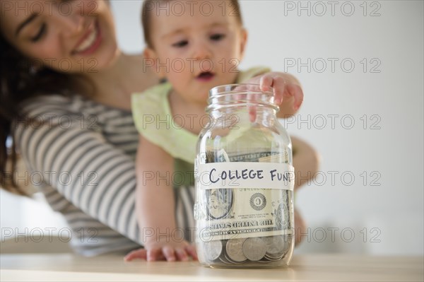 Mother and baby putting money in college fund