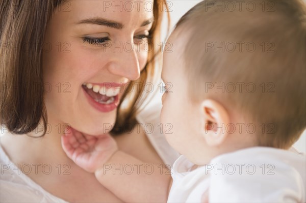 Smiling mother playing with baby