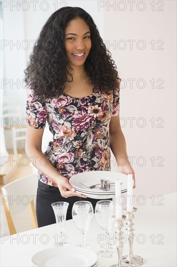 Mixed race woman setting table