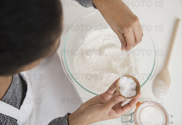 Mixed race woman baking in kitchen