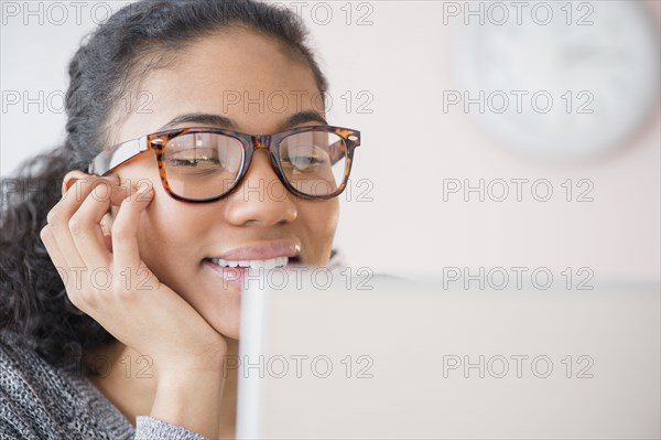 Mixed race woman using laptop computer