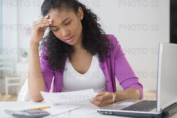 Mixed race woman paying bills online