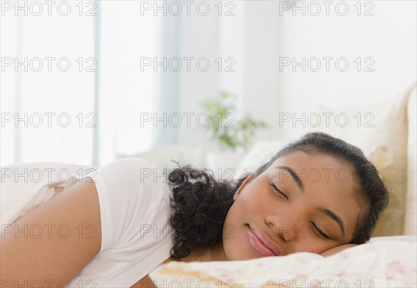 Mixed race woman sleeping in bed