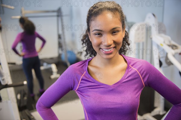 Mixed race woman smiling in gym