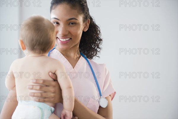 Nurse holding baby in hospital