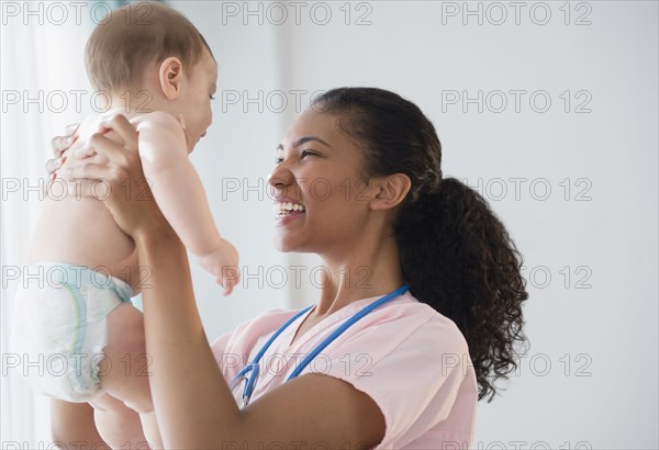 Nurse holding baby in hospital