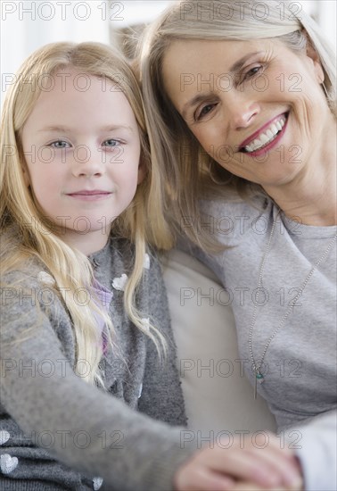 Senior Caucasian woman and granddaughter sitting on sofa