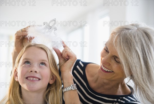 Senior Caucasian woman crowning granddaughter