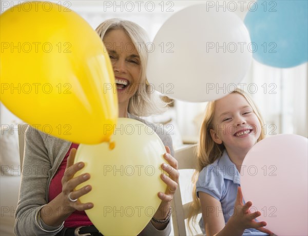 Senior Caucasian woman and granddaughter playing with balloons