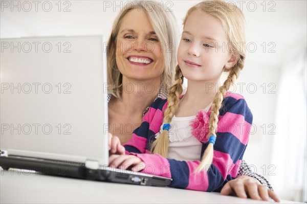Senior Caucasian woman and granddaughter using laptop