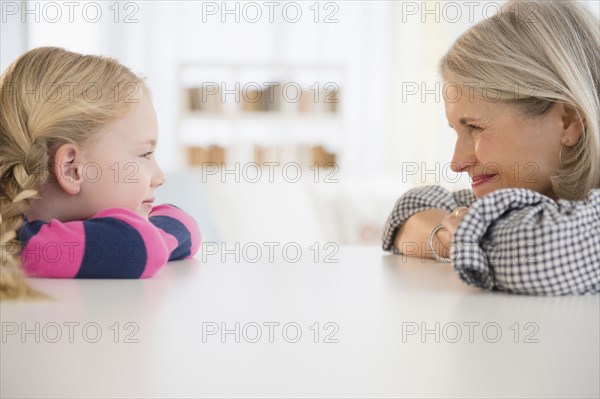 Senior Caucasian woman and granddaughter sitting at table