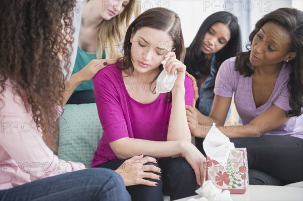 Crying woman surrounded by friends