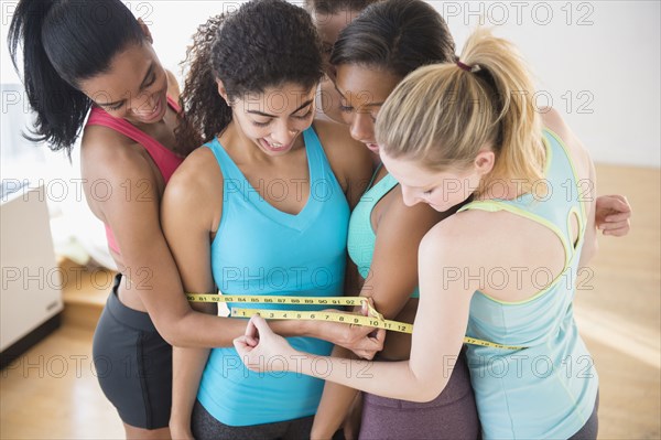 Women measuring their waistlines together