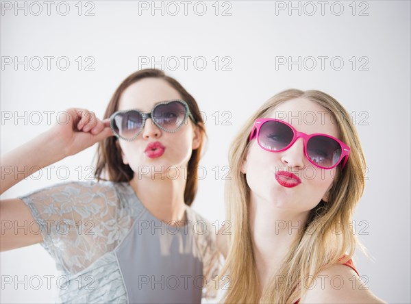 Women wearing colorful sunglasses and lipstick