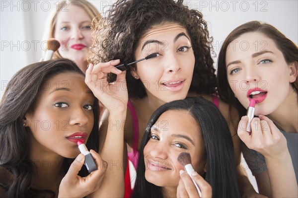 Women applying makeup in mirror