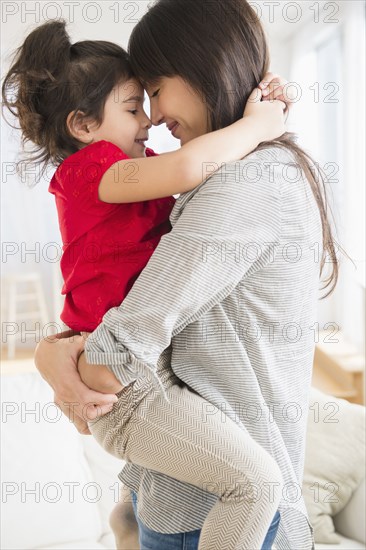 Hispanic mother and daughter hugging