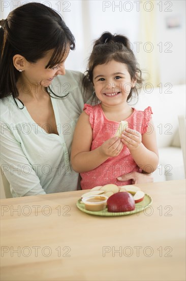 Hispanic mother and daughter eating together