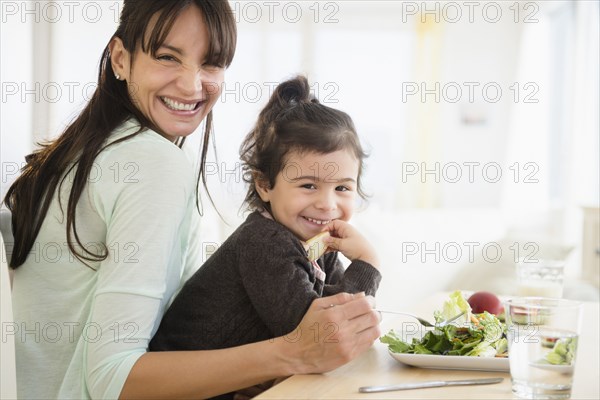 Hispanic mother and daughter eating together