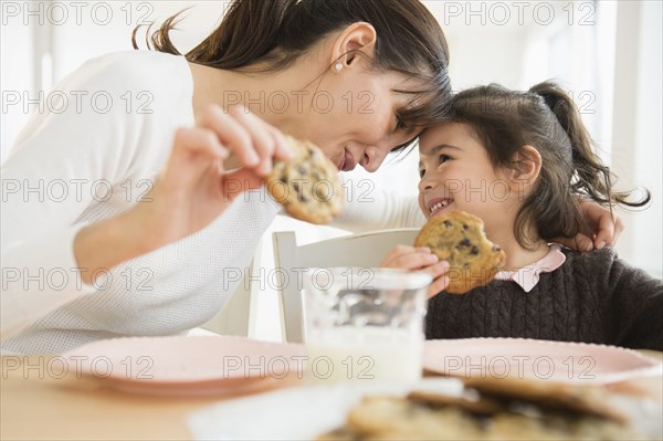 Hispanic mother and daughter eating together