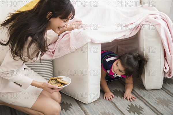 Hispanic mother bringing daughter cookies in fort