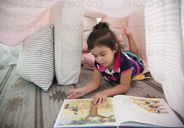 Hispanic girl reading in fort