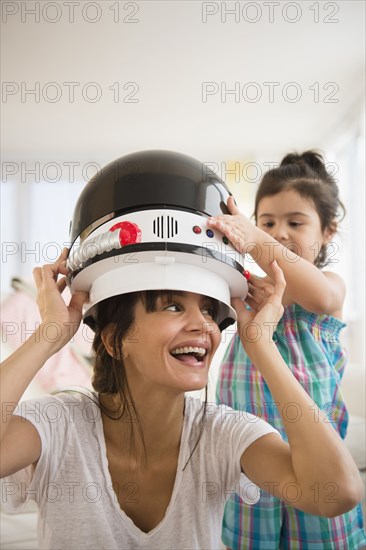 Hispanic mother and daughter playing dress up